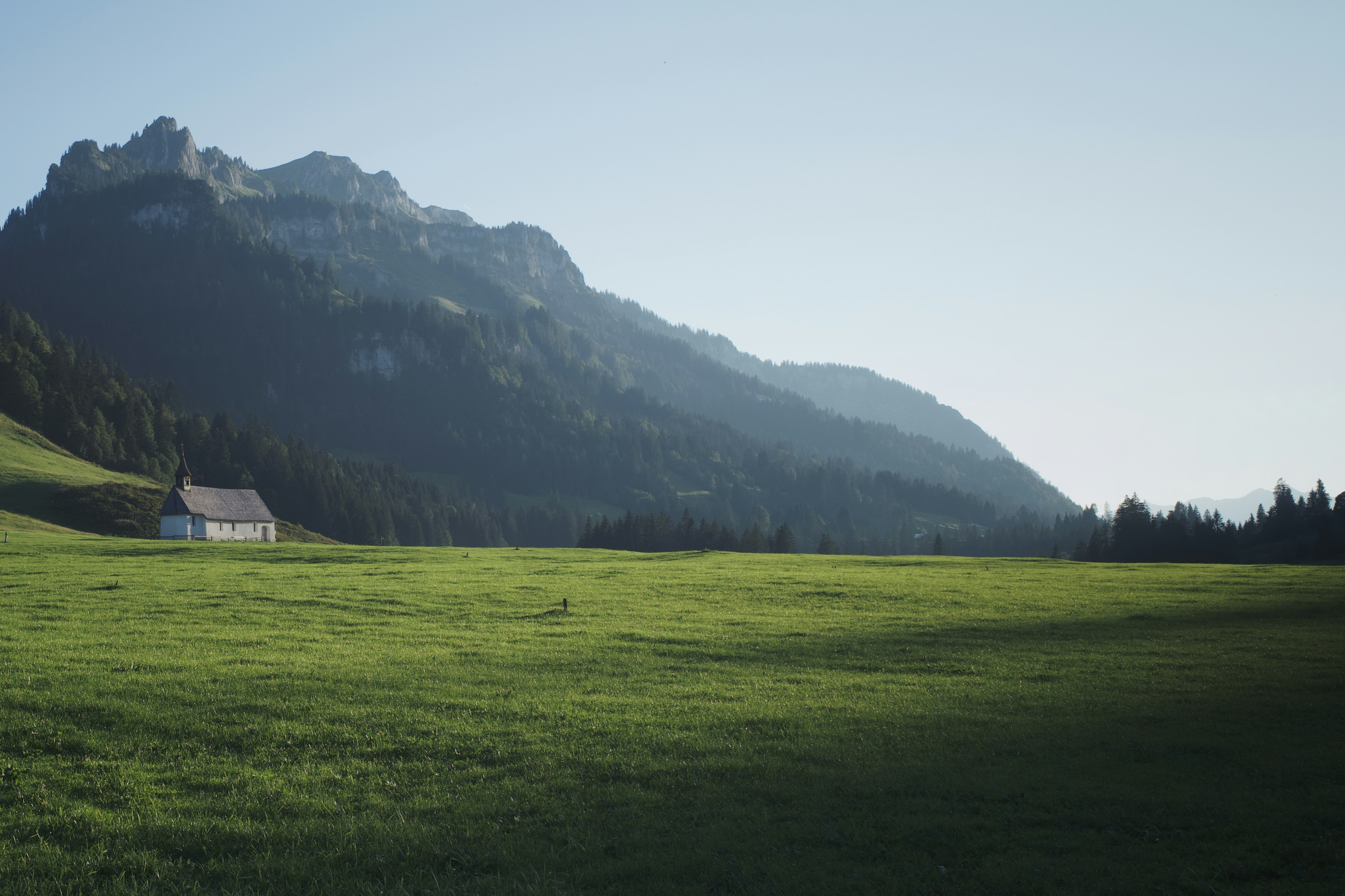 green grass field near mountain during daytime