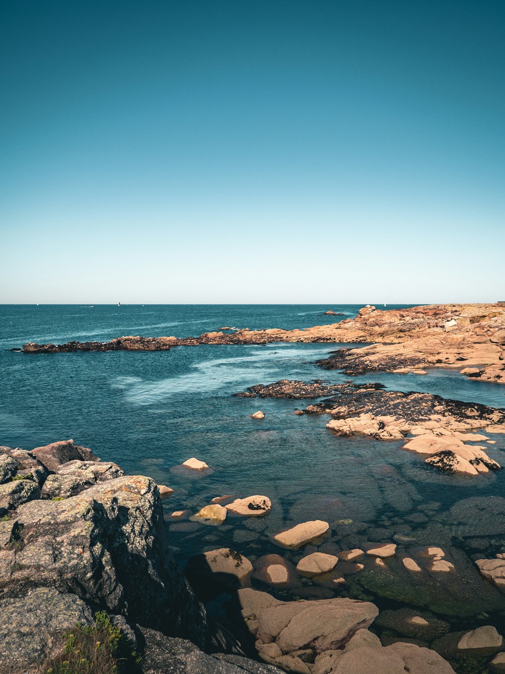 rocky shore under blue sky during daytime