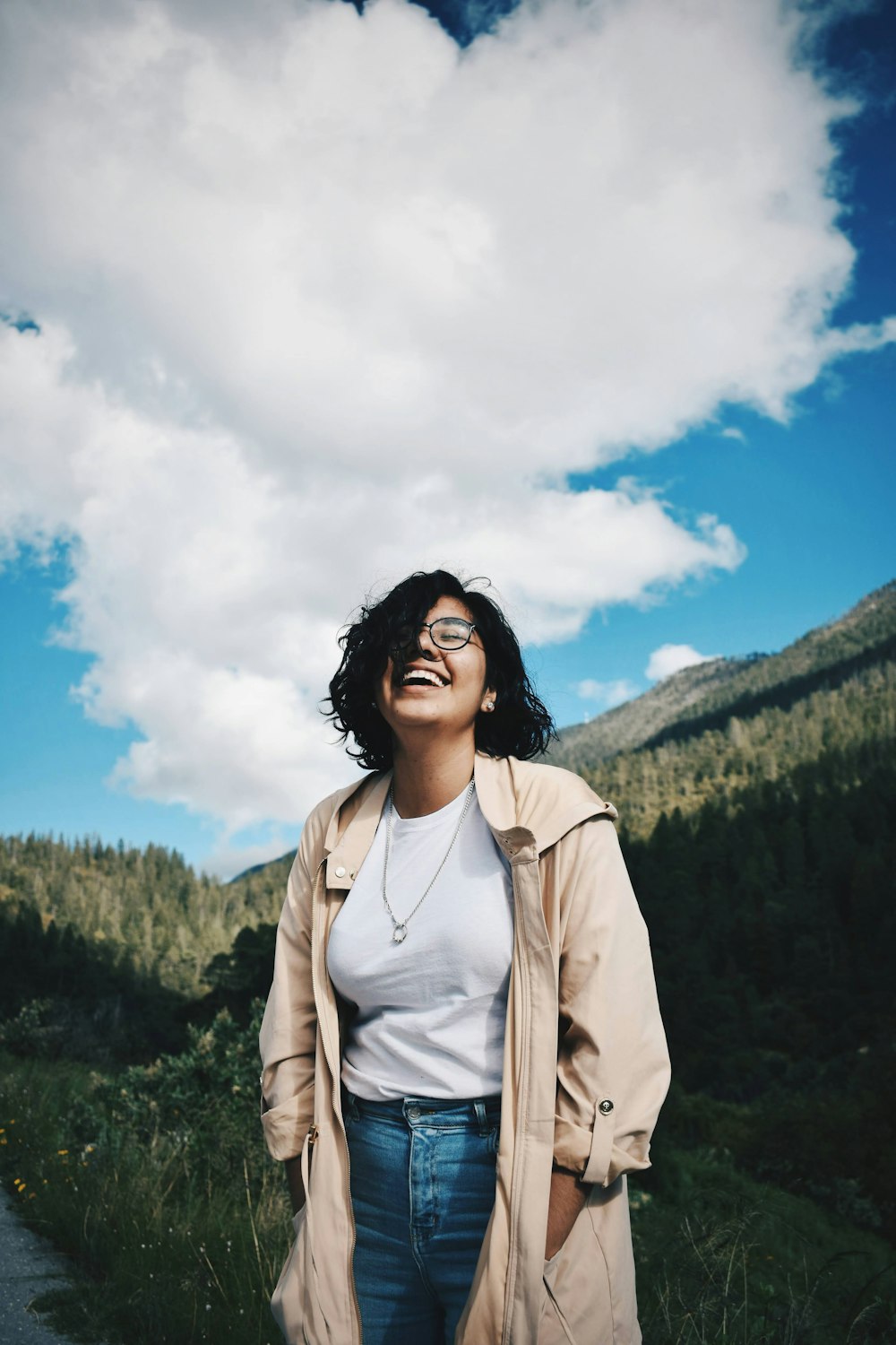 woman in brown jacket standing on green grass field during daytime