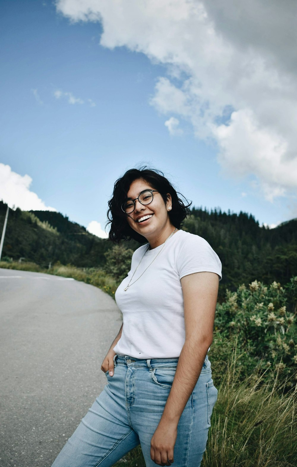 woman in white crew neck t-shirt standing on road during daytime