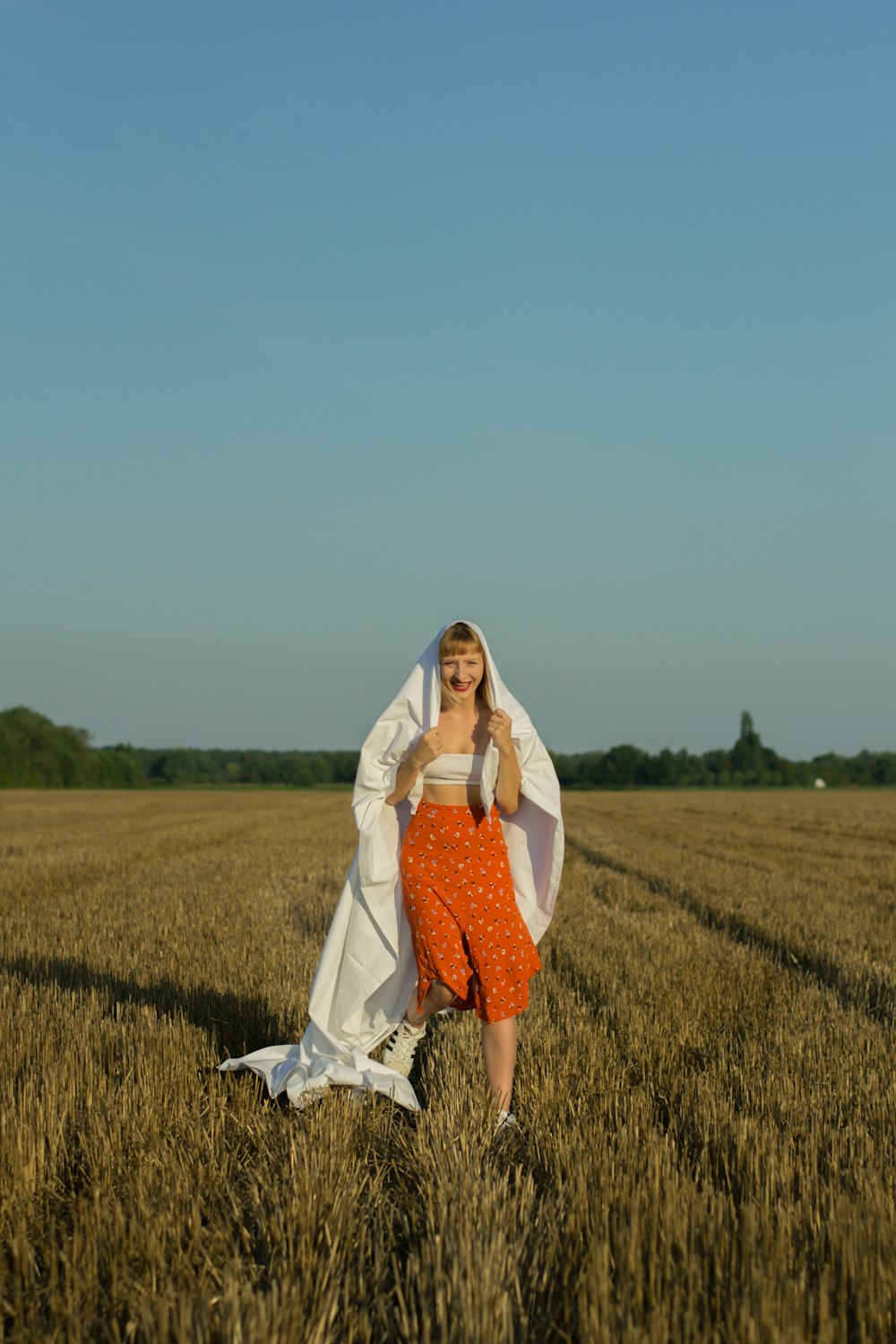 woman in white long sleeve dress standing on green grass field during daytime