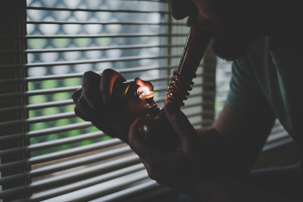 man in white shirt holding black hookah