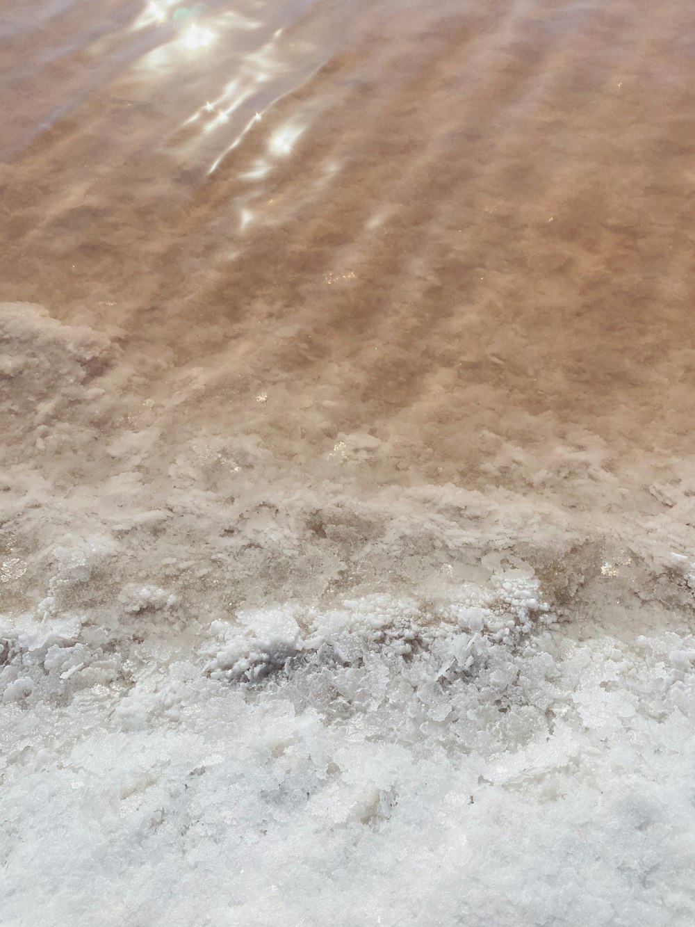 Wasserwellen auf braunem Sand