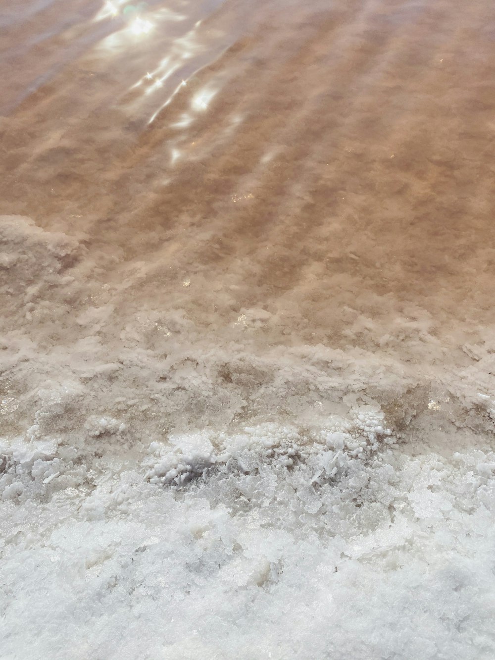 茶色の砂浜に波打つ水