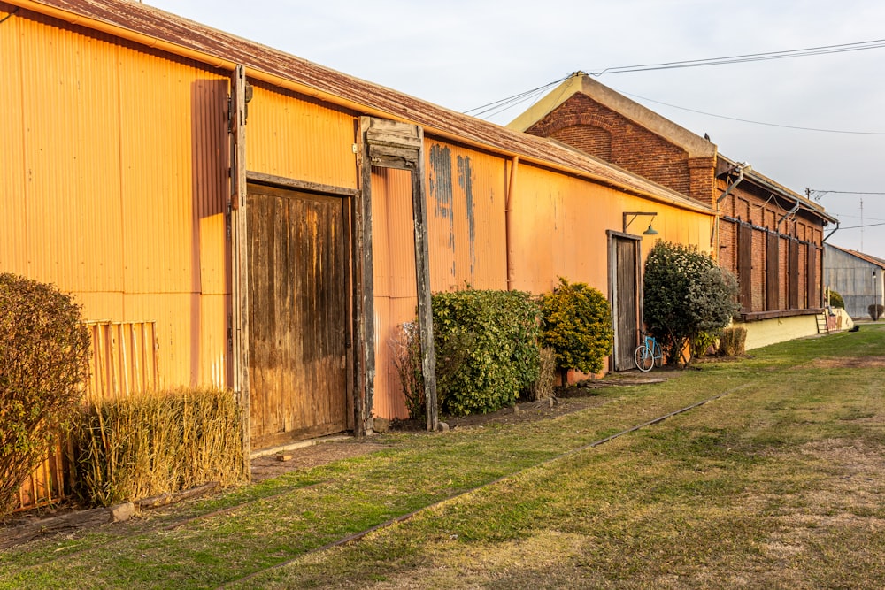 brown wooden house near green trees during daytime