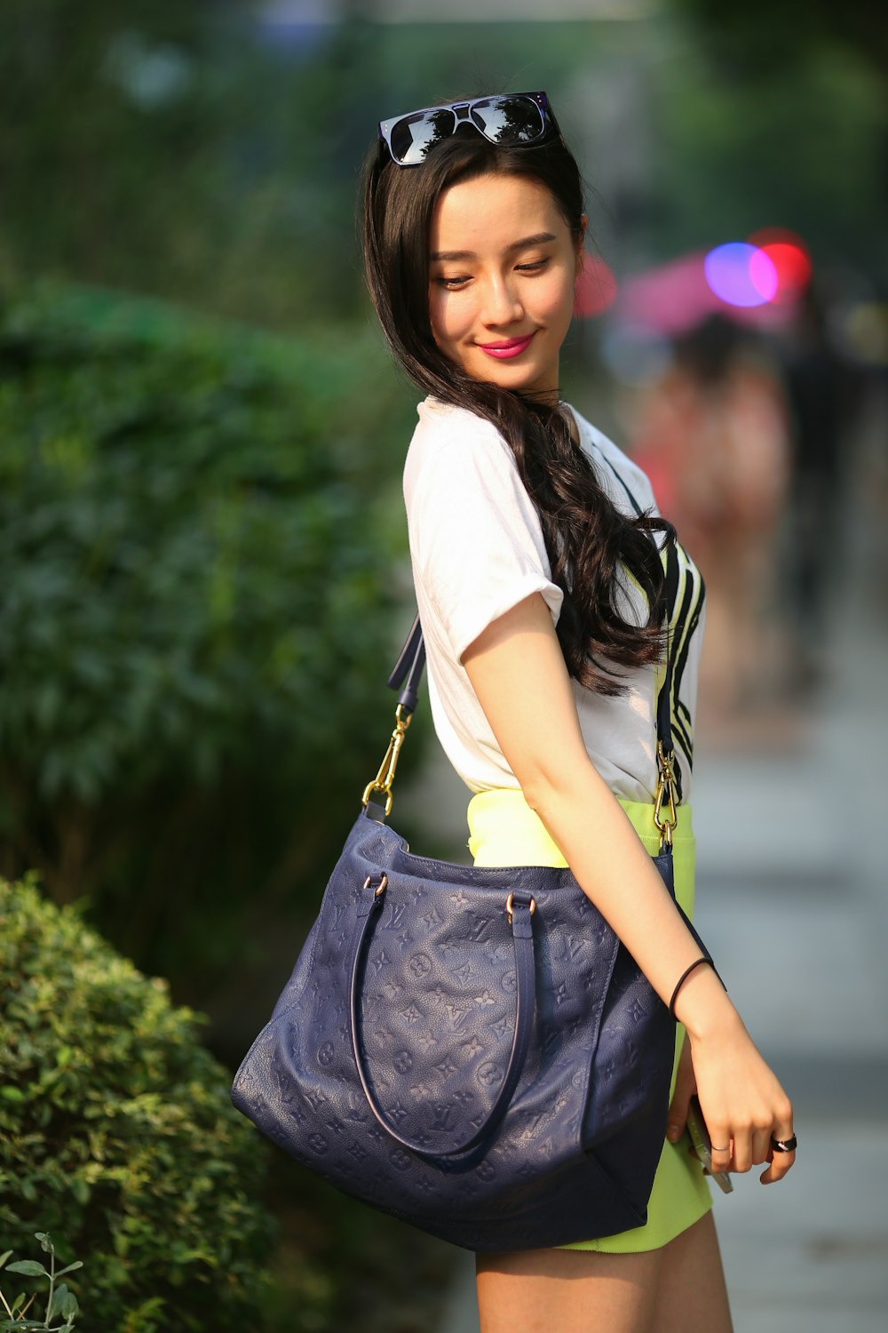 woman in white shirt and black leather sling bag