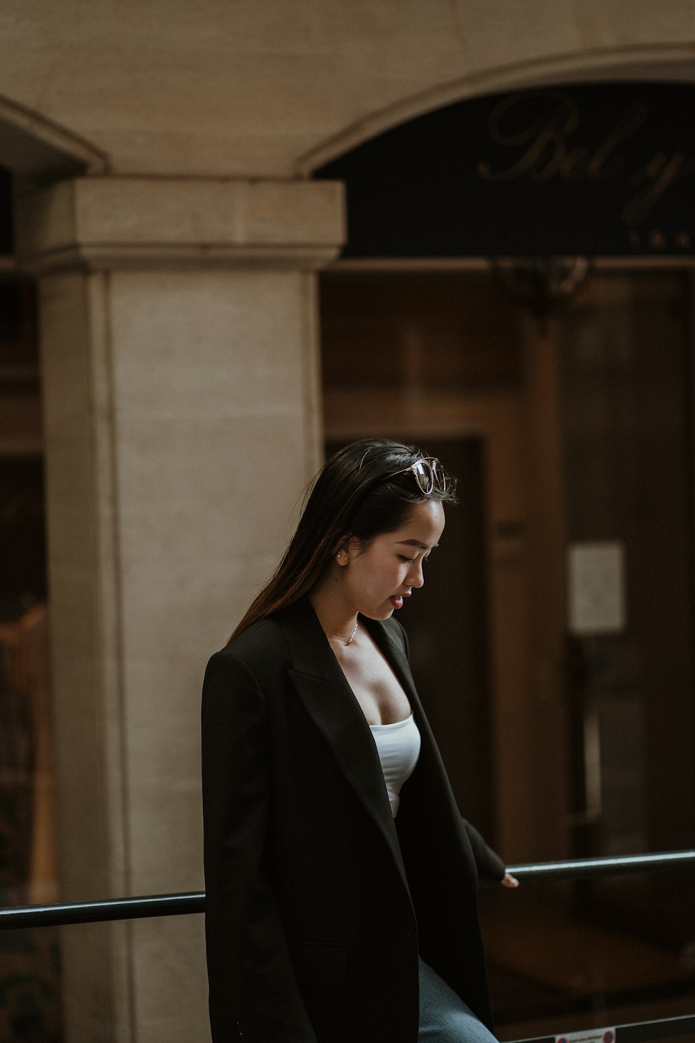 woman in black blazer standing near brown concrete building during daytime