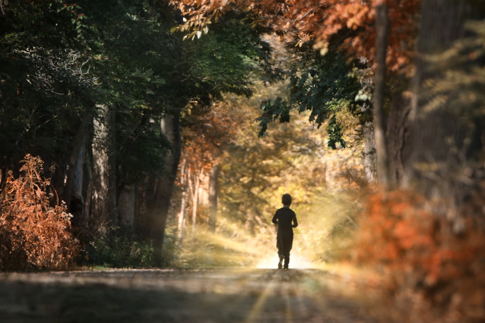 man in black jacket walking on road during daytime