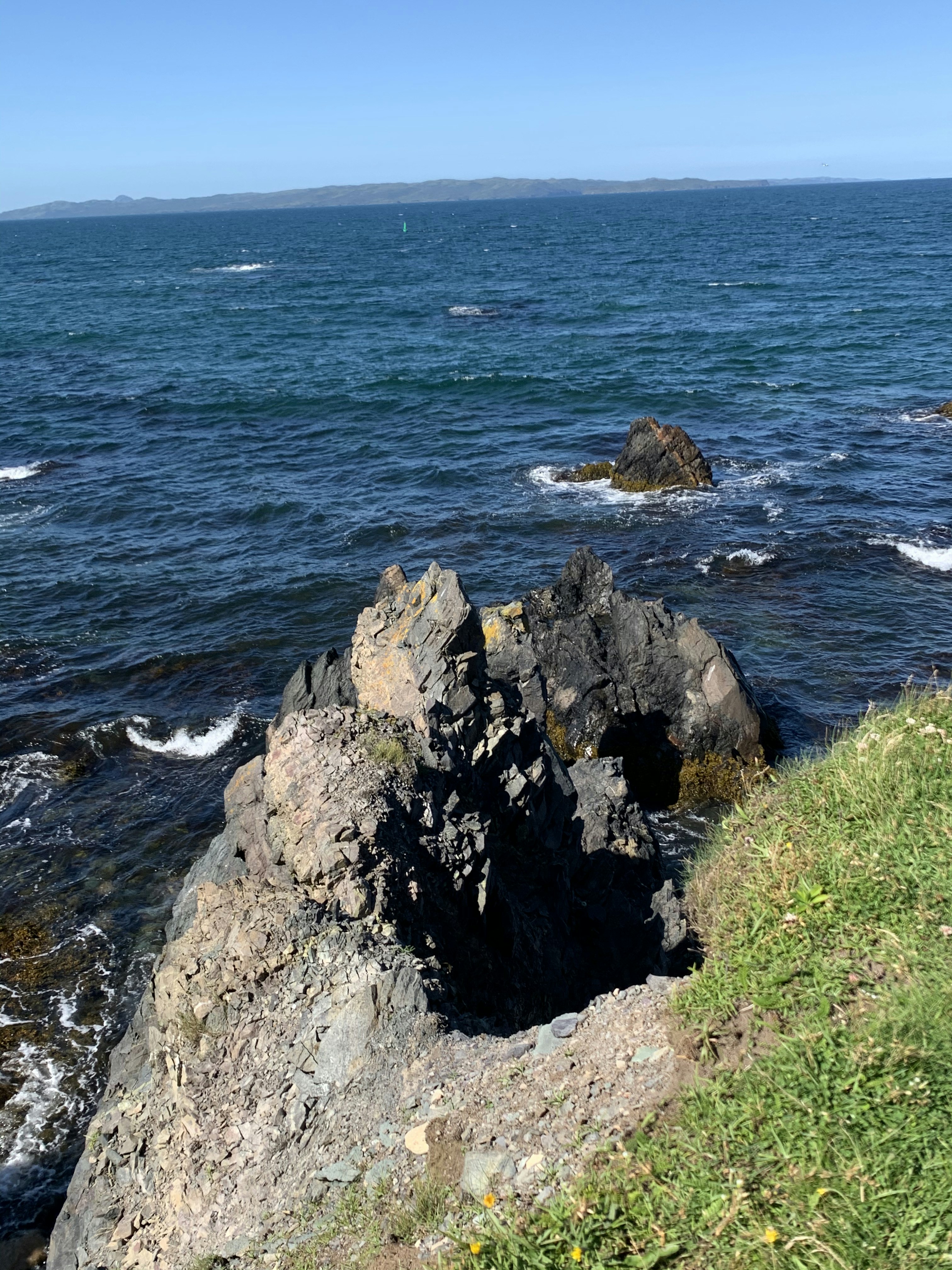 brown rock formation near body of water during daytime