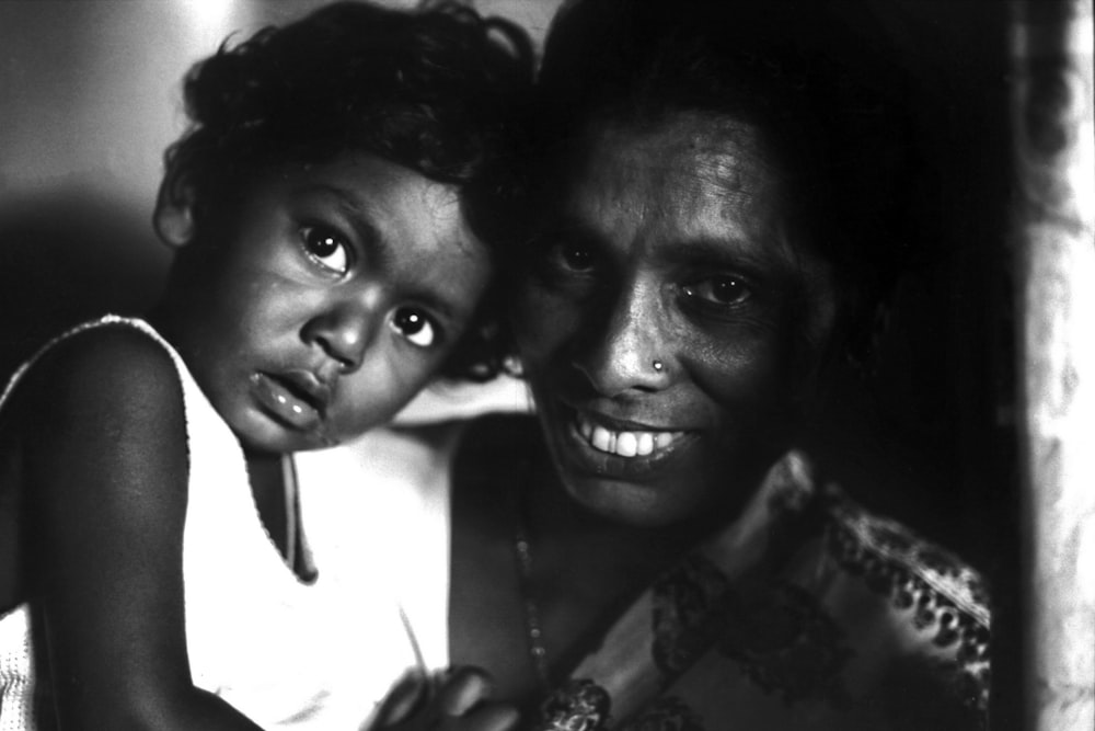 man and woman smiling in grayscale photography