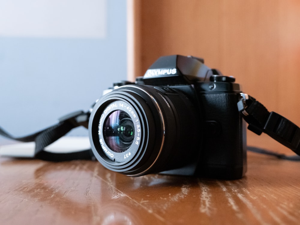 black nikon dslr camera on brown wooden table