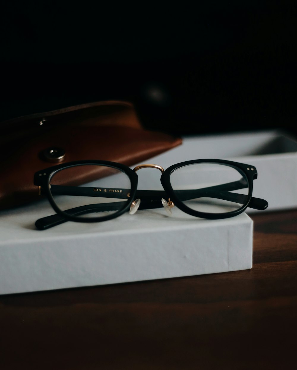 black framed eyeglasses on white paper