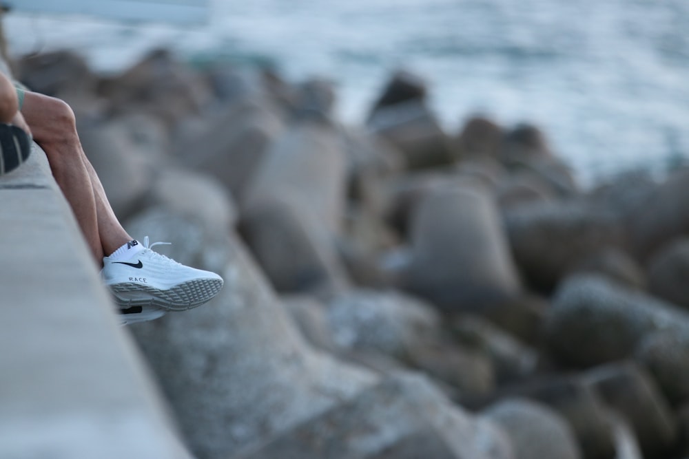 white and black nike sneakers on rocky shore during daytime