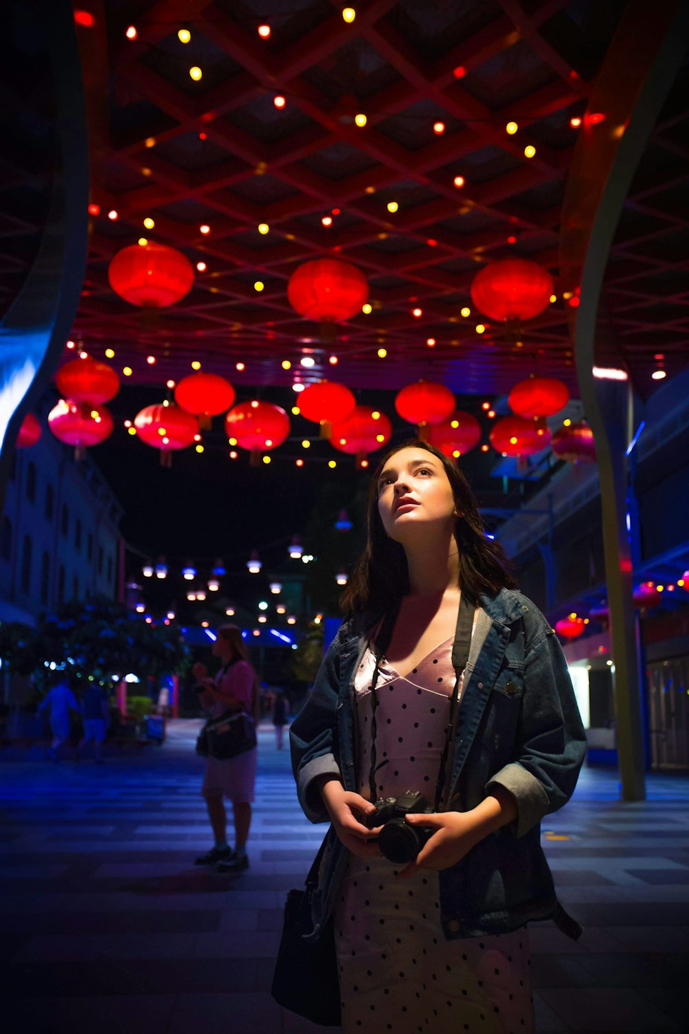 woman in black jacket standing on street during night time