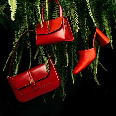red leather handbag on green pine tree