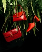 red leather handbag on green pine tree