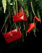 red leather handbag on green pine tree