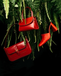 red leather handbag on green pine tree