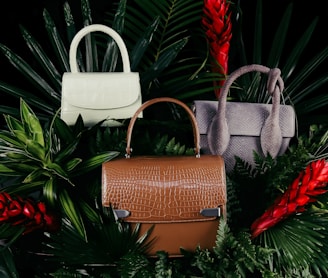 brown leather handbag on green pine tree