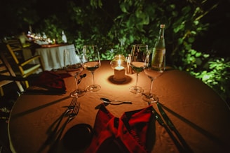 An inviting dining table set for a romantic dinner with candles and wine glasses.