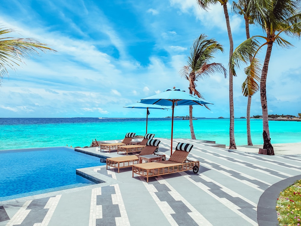 brown wooden lounge chairs on beach during daytime