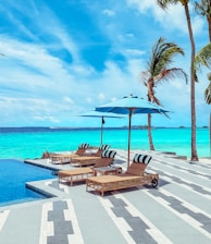 brown wooden lounge chairs on beach during daytime