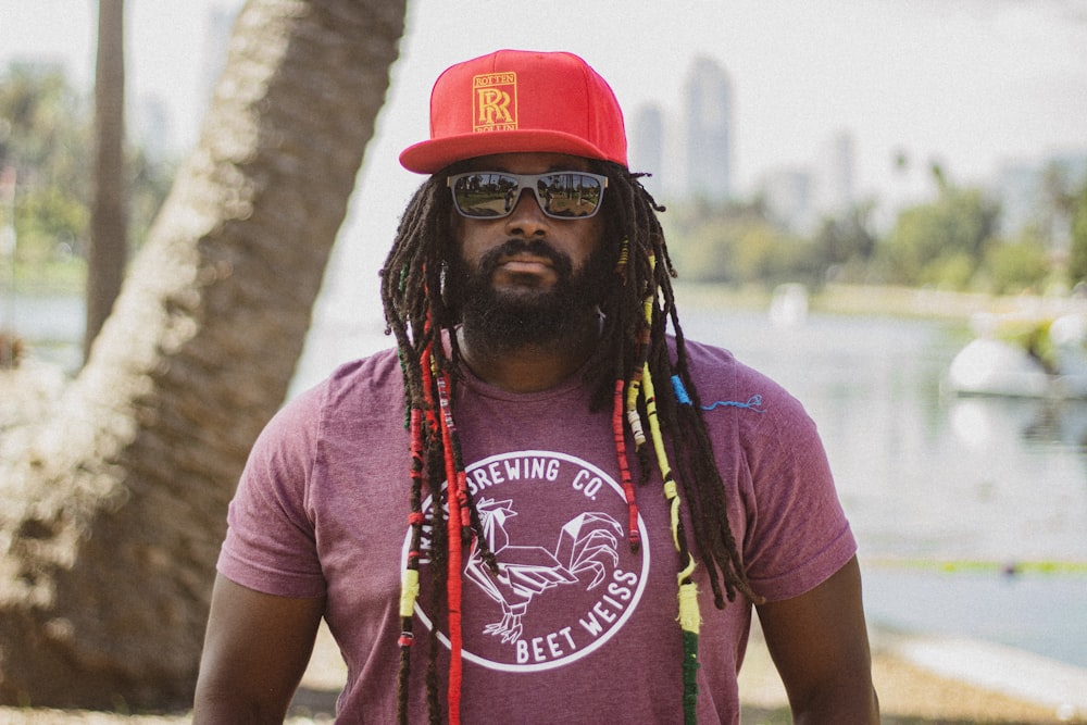 man in red and white crew neck t-shirt wearing red cap