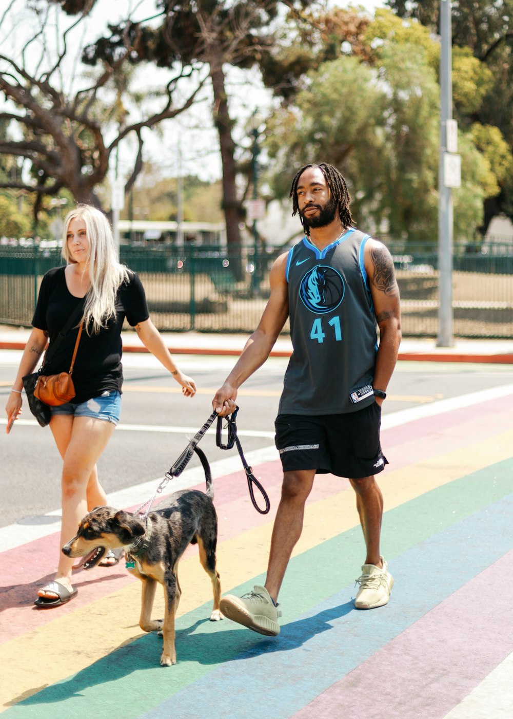 woman in blue crew neck t-shirt and black shorts holding black and brown short coated