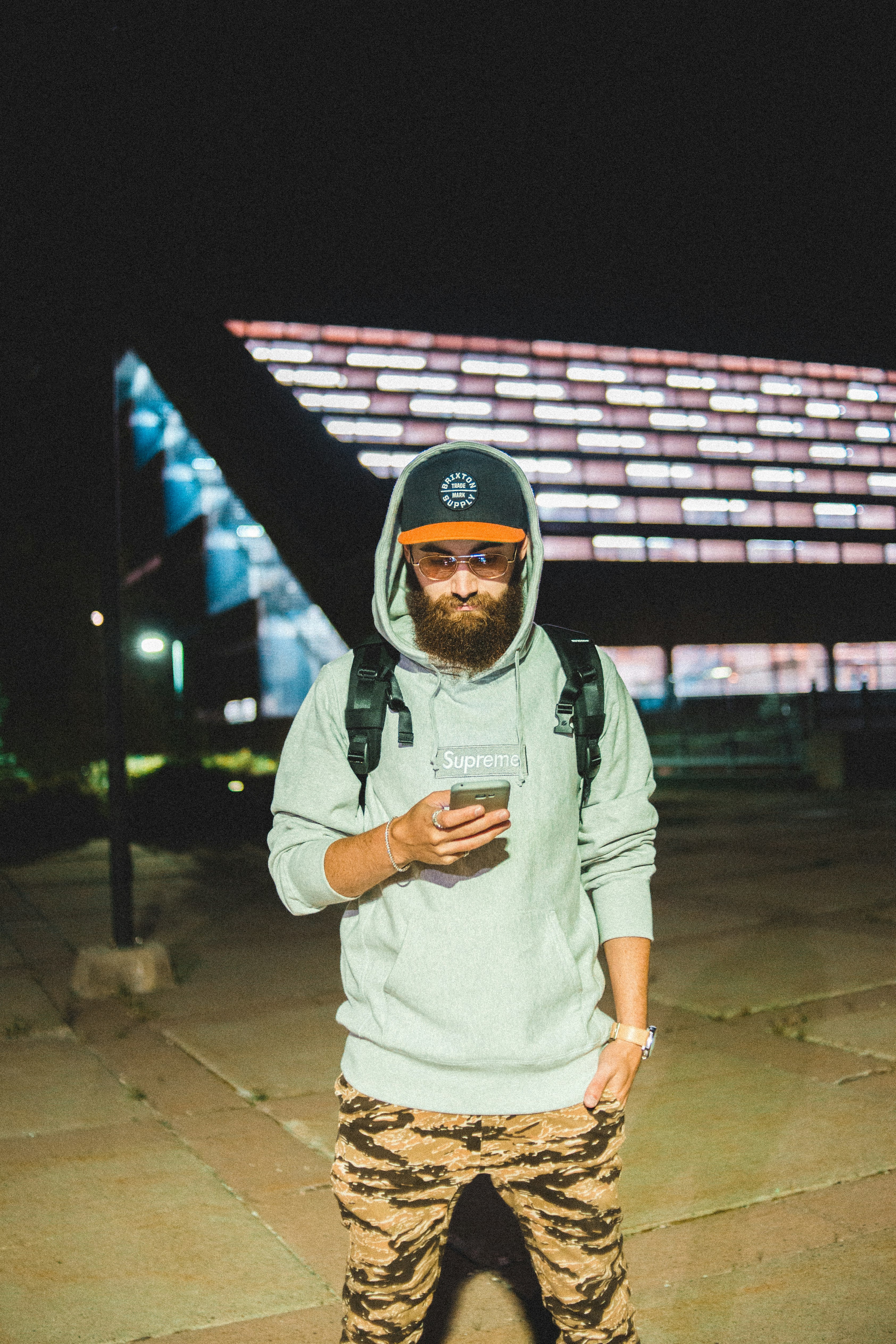 man in gray hoodie wearing black and red cap