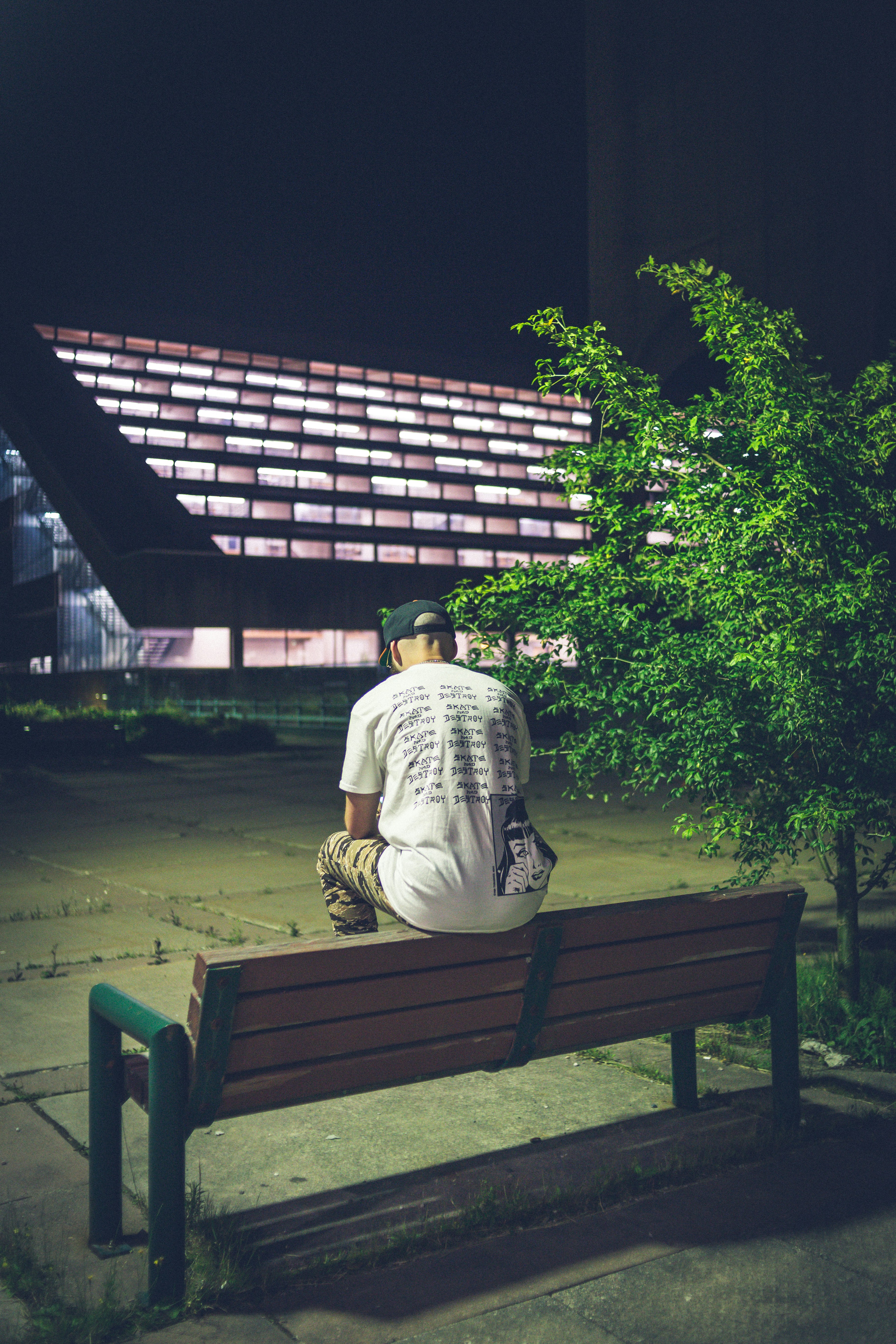 man in white shirt sitting on brown wooden bench