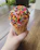 Close-up of a pastel pink ice cream cone with sprinkles on a sunny day