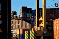 Image of shipping containers being loaded at an Australian port at sunrise.