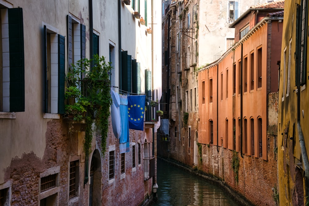 blue boat on river between brown concrete buildings during daytime