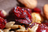 Close-up of vibrant freeze-dried cranberries arranged on a rustic wooden table.
