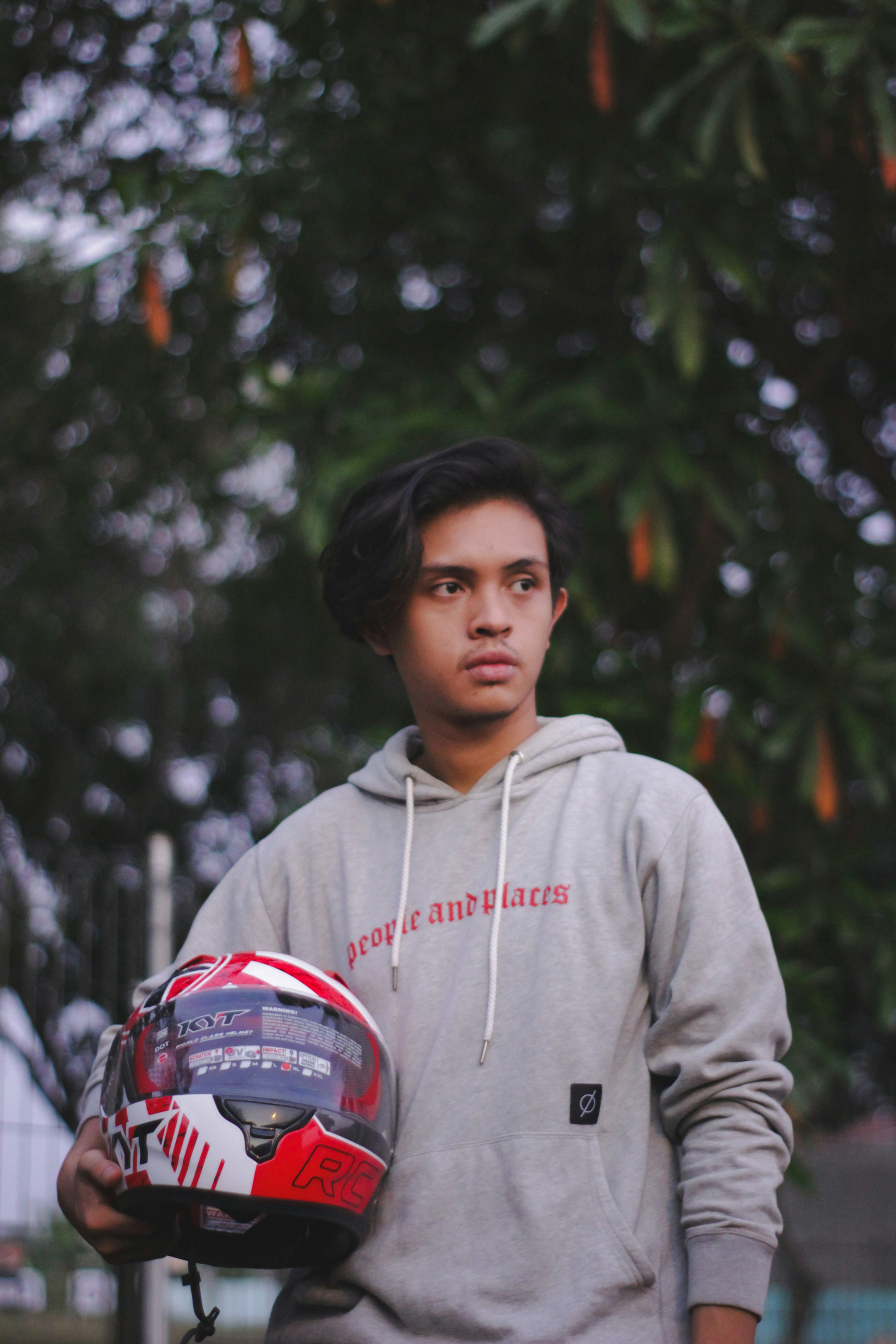 boy in gray hoodie wearing red and white helmet