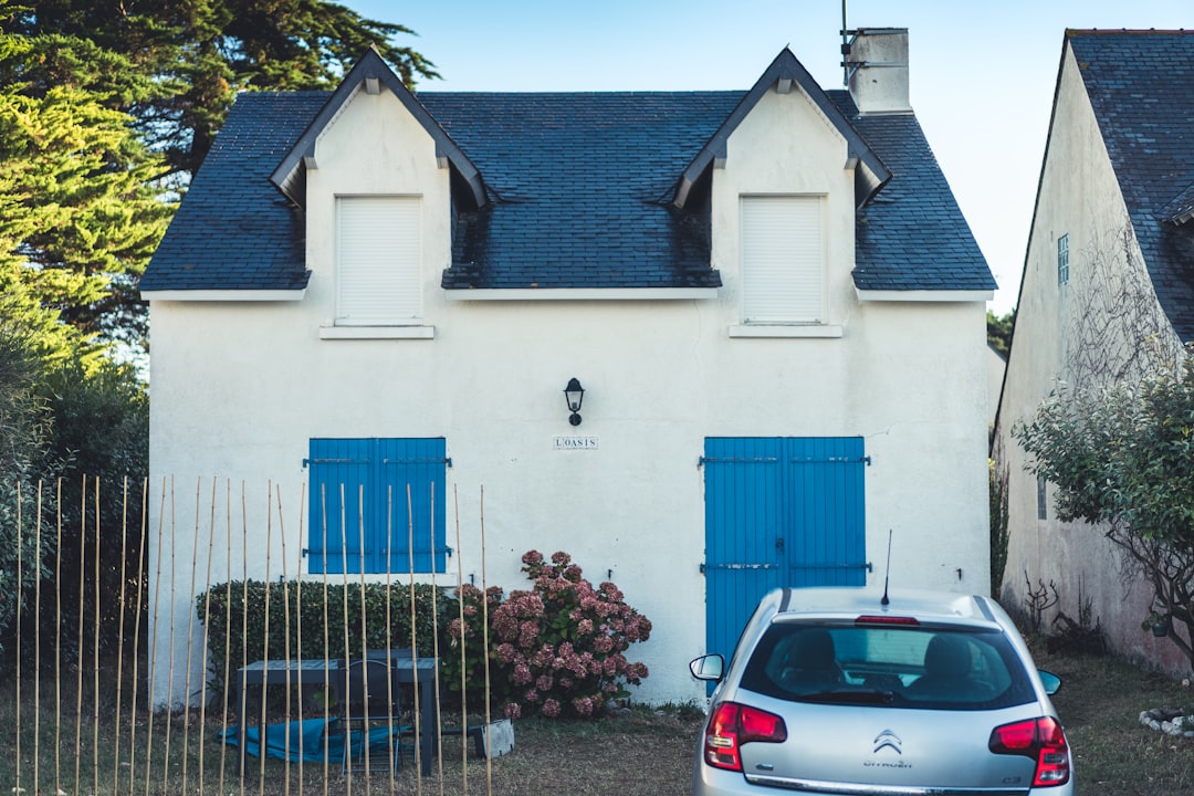 blue and white concrete house with blue metal gate