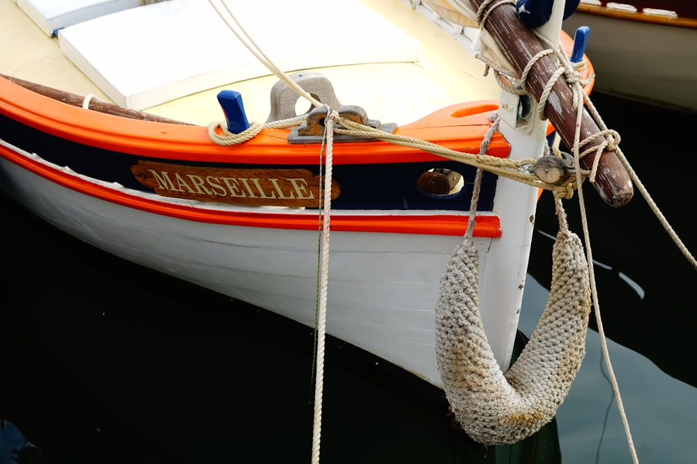 white and orange boat on water