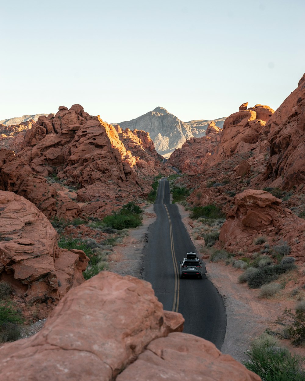 carro preto na estrada perto da montanha rochosa marrom durante o dia