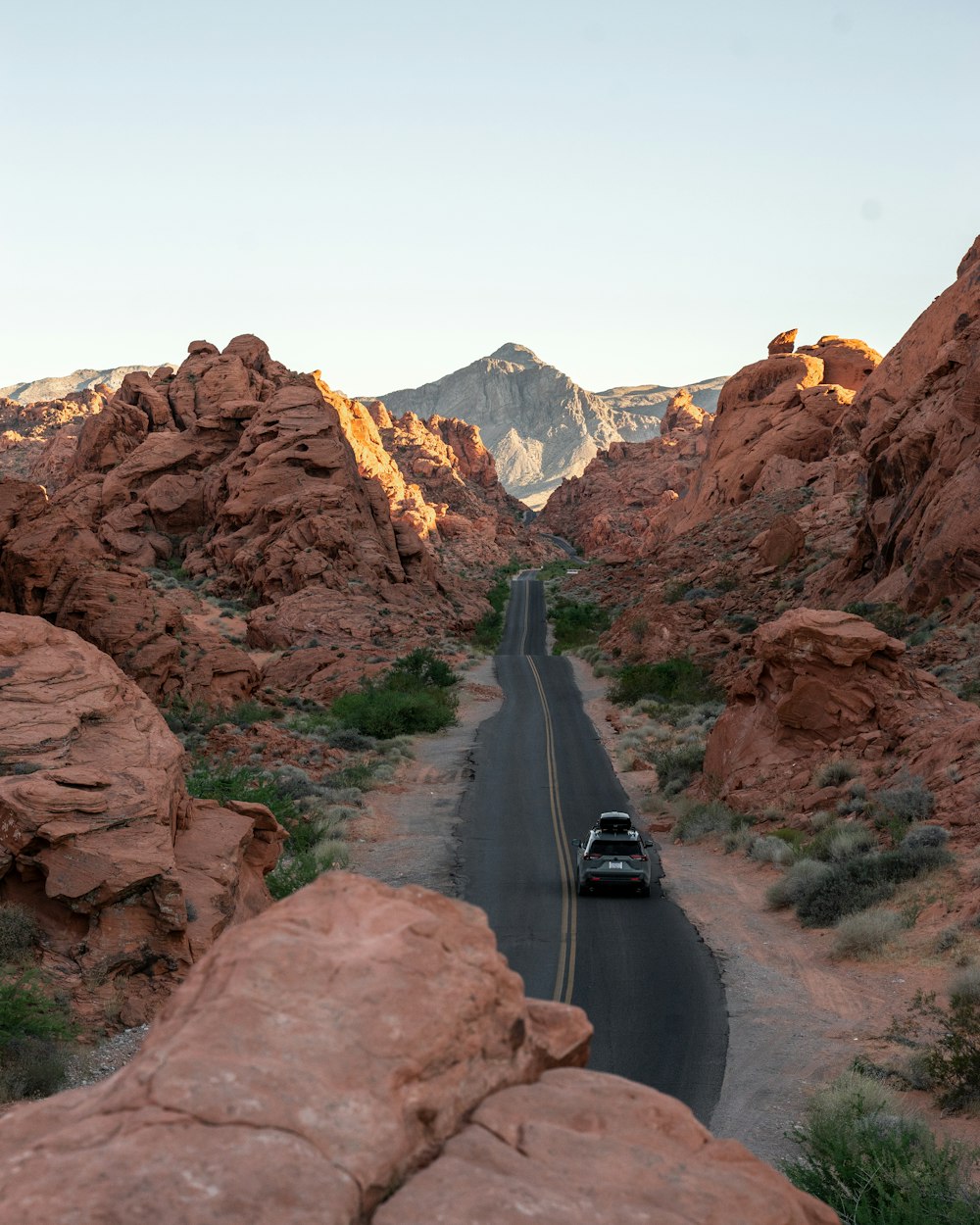 black car on road near brown rocky mountain during daytime