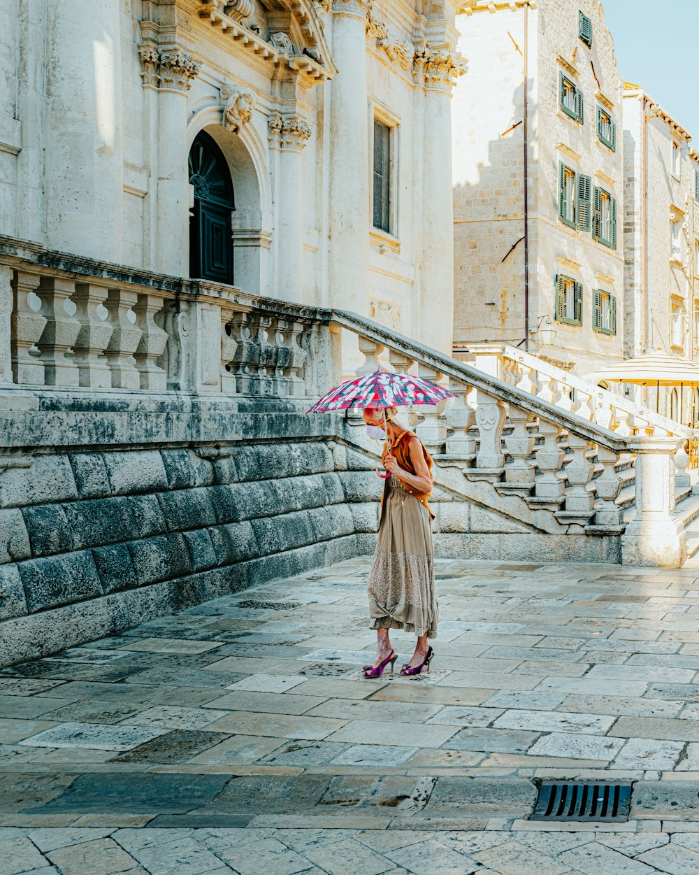 a woman in a dress holding an umbrella