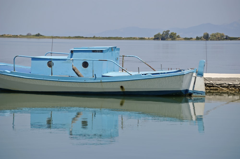 white and blue boat on water during daytime