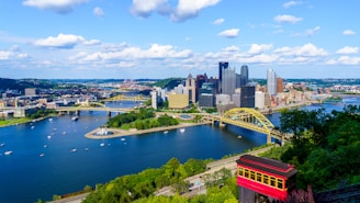 red and black train on bridge over body of water during daytime