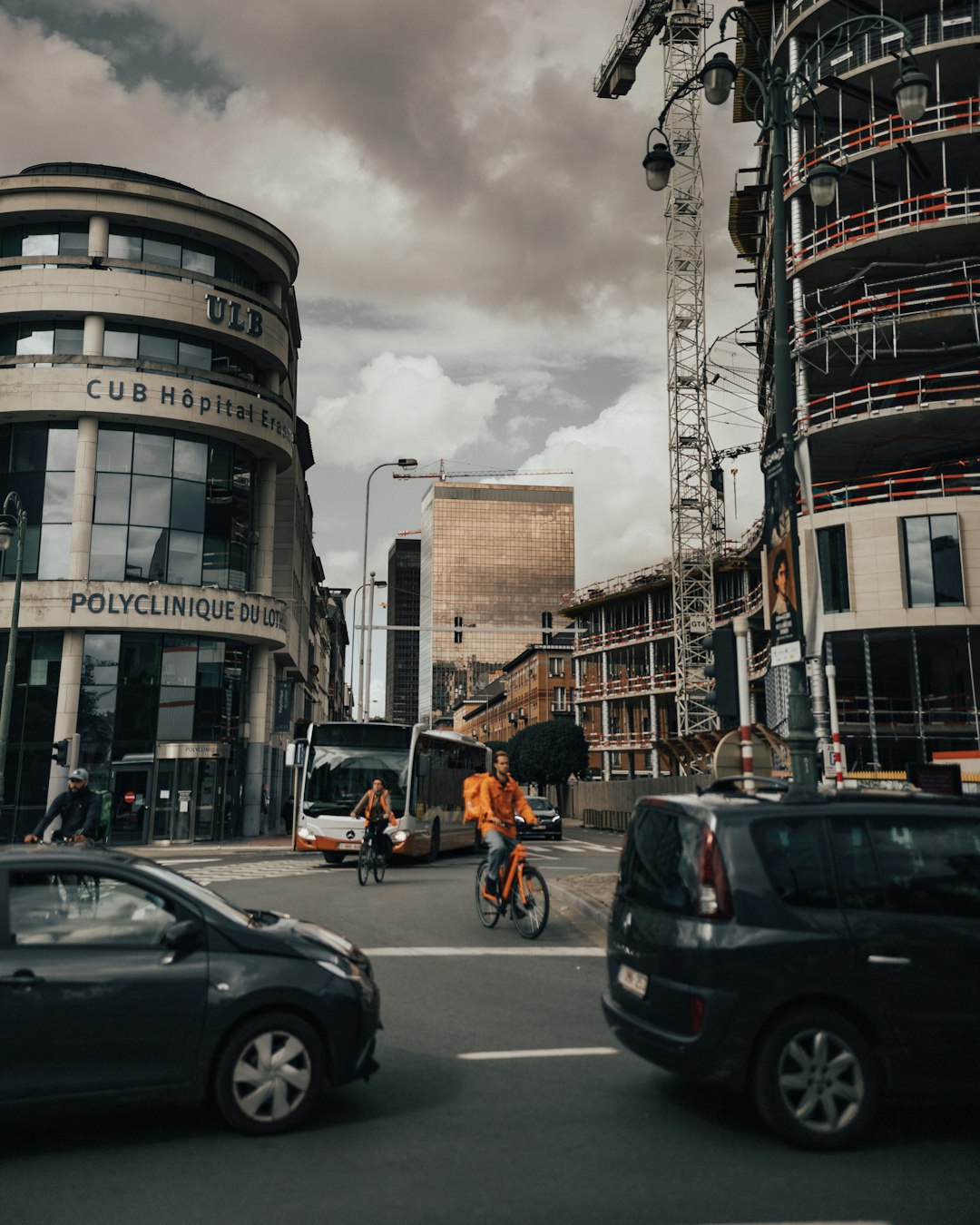 people walking on pedestrian lane near cars and buildings during daytime