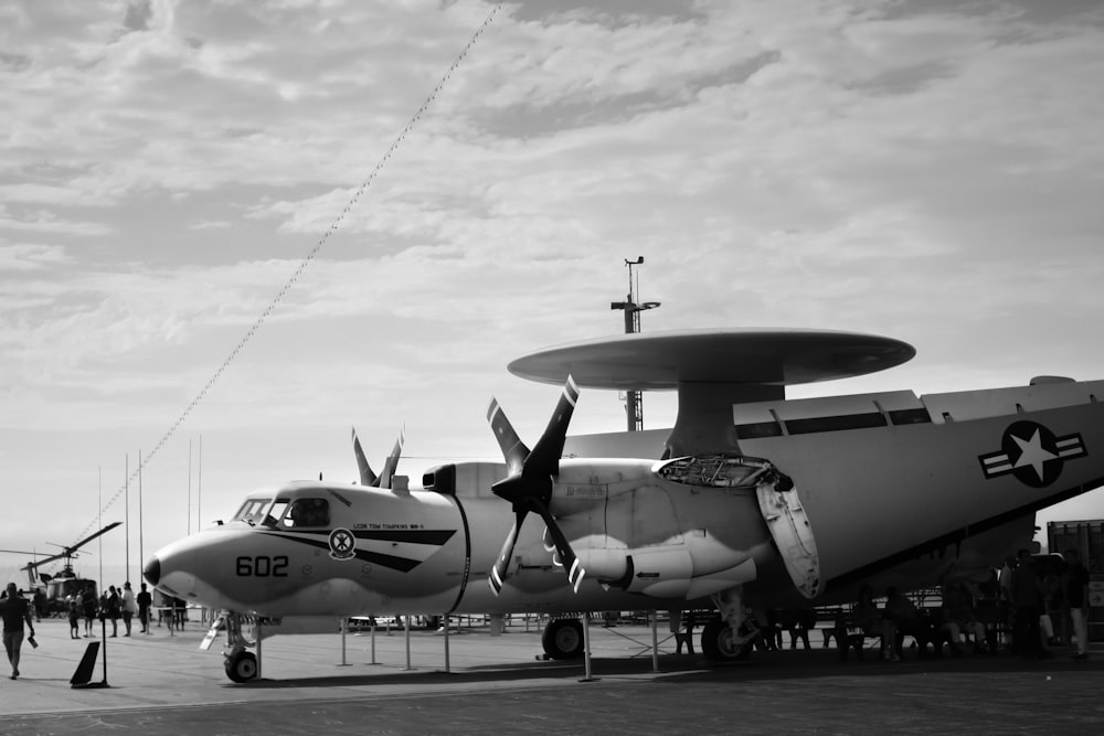 gray fighter plane on gray concrete ground under cloudy sky during daytime