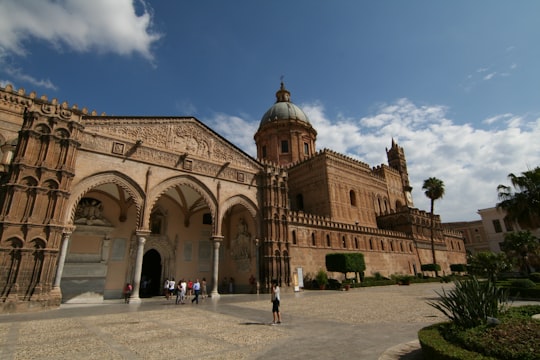 people walking near brown concrete building during daytime in Cattedrale di Palermo Italy