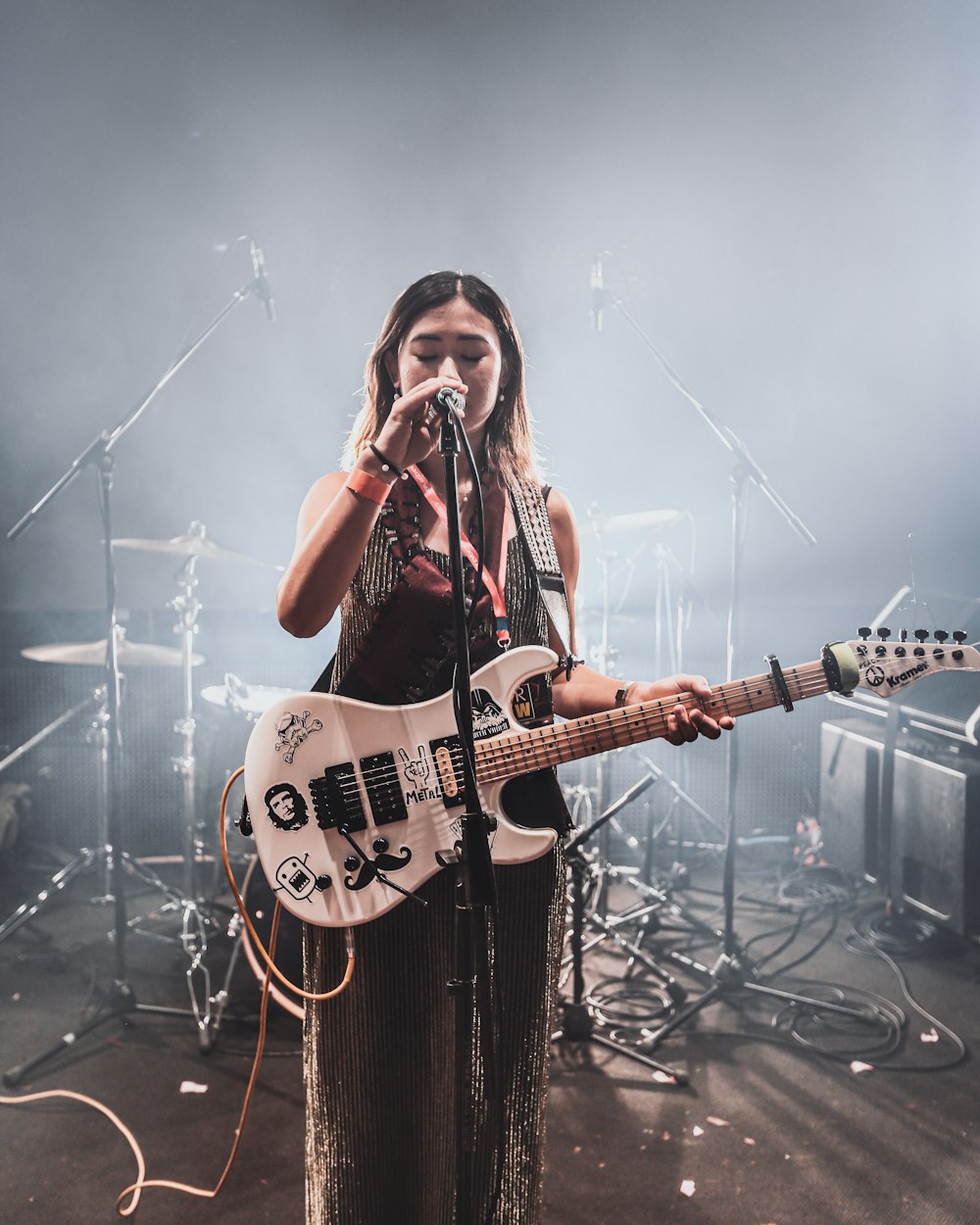 Femme en chemise à carreaux blanche et noire jouant de la guitare électrique