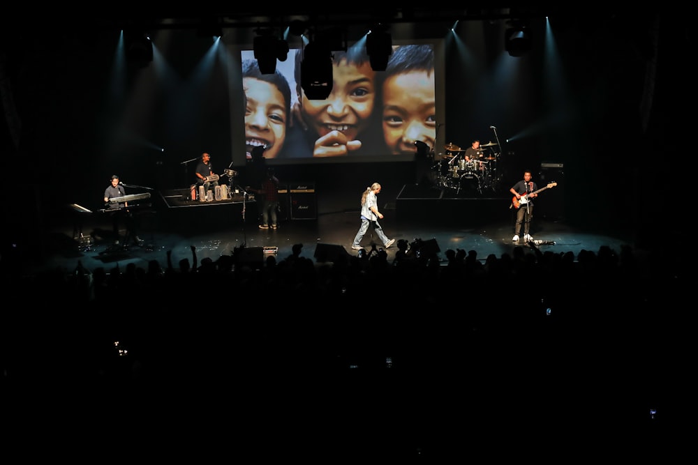 man in white long sleeve shirt singing on stage