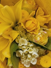 A close-up of a vibrant floral arrangement showcasing a mix of roses, lilies, and greenery.