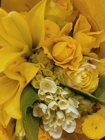 A close-up of a vibrant floral arrangement showcasing a mix of roses, lilies, and greenery.