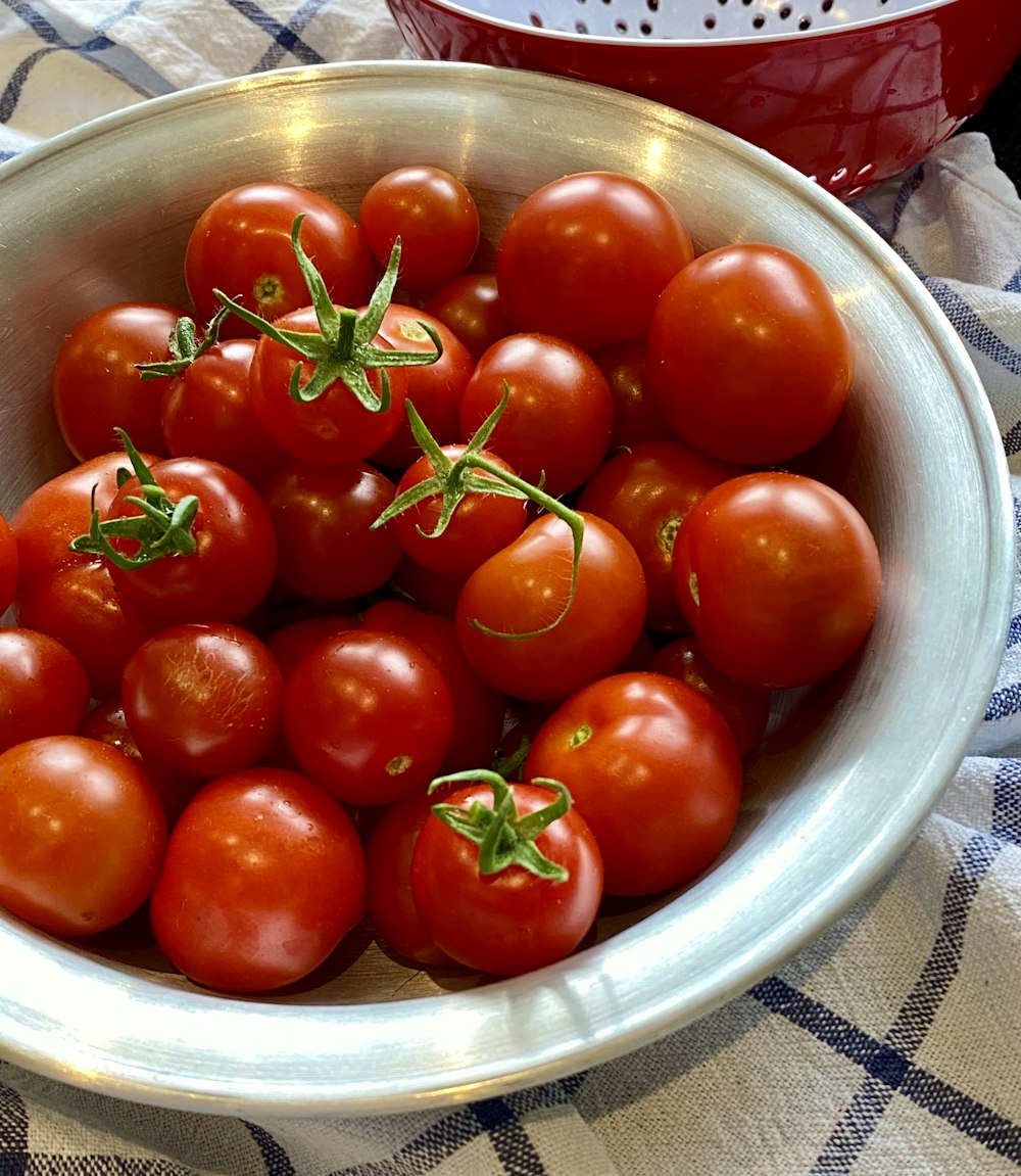 red tomatoes on stainless steel bowl